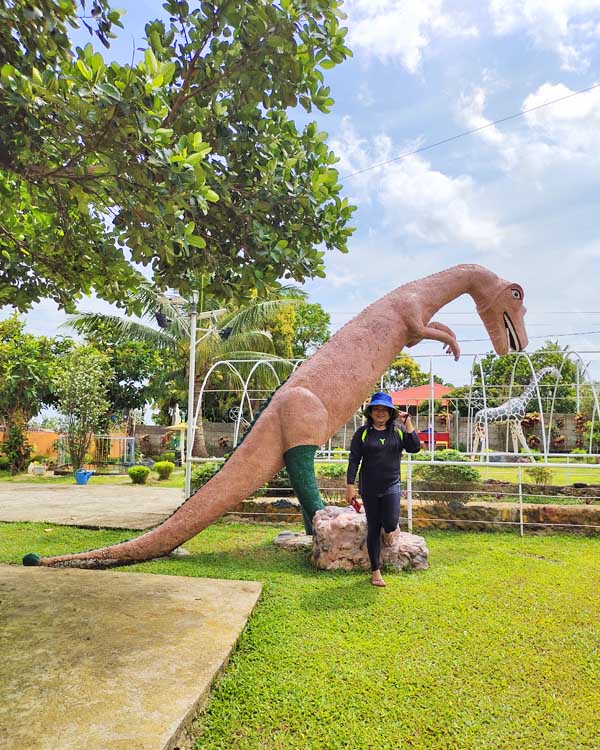 Getting a picture beside a T-Rex dinosaur statue.