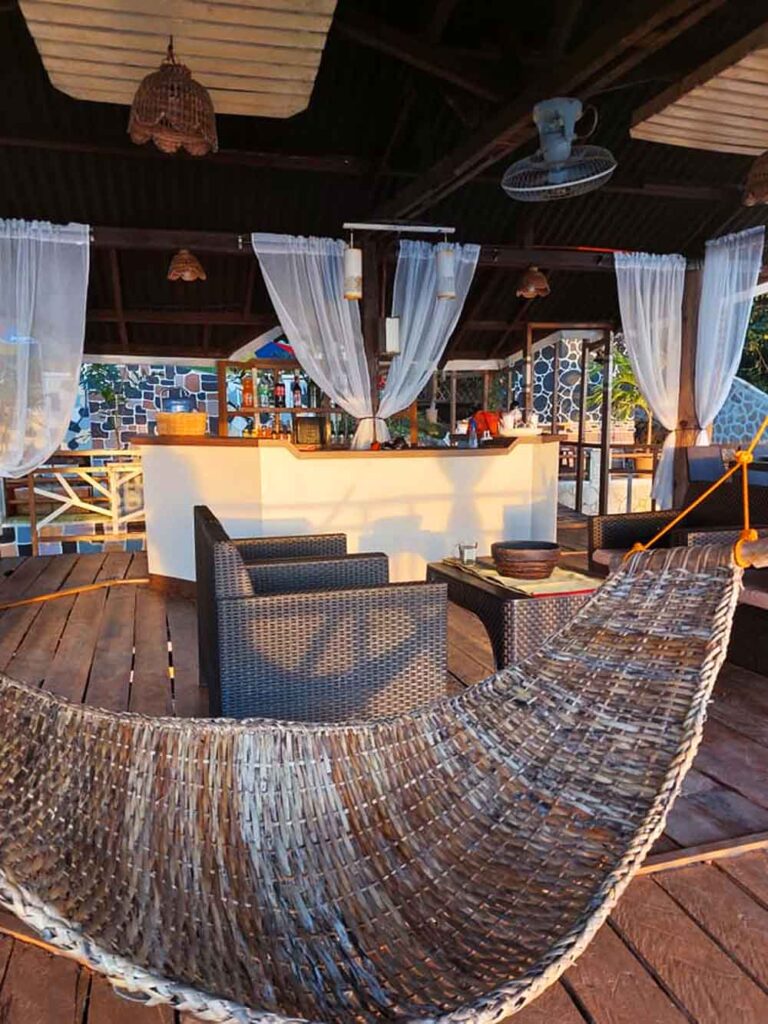 The minibar and a wicker hammock grazed by the sunset rays.