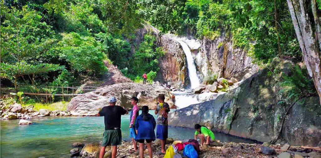 Some visitors talking with a foreigner near the basin of Tinago Falls.