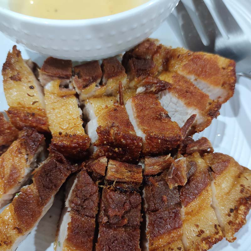 Lechon kawali with a sauce served on plate.