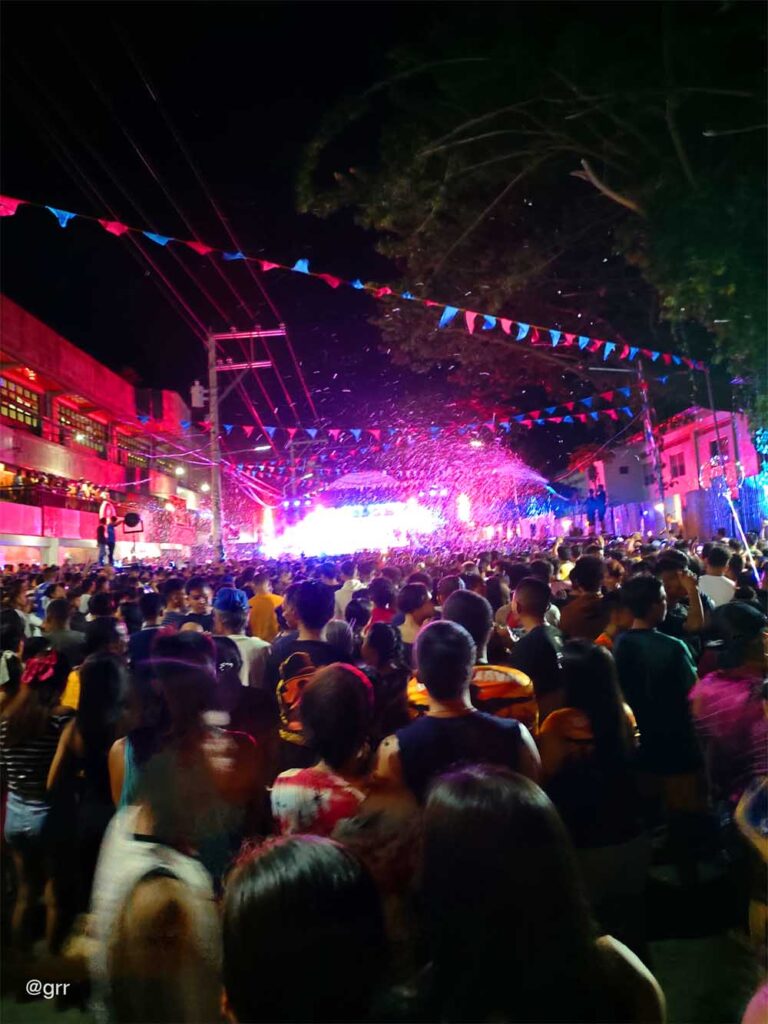 Colorful lights dominated by purple and the crowd vibing the party.