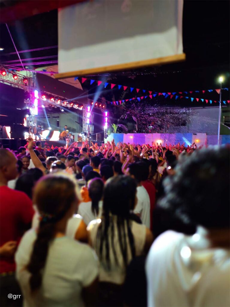 Crowd watching the DJs and performers at the side.