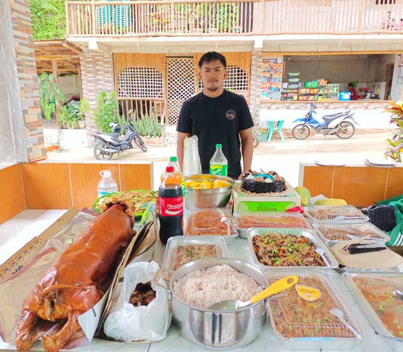 A guest celebrating his birthdays with the Lechon Food Package on the table inside the cottage.